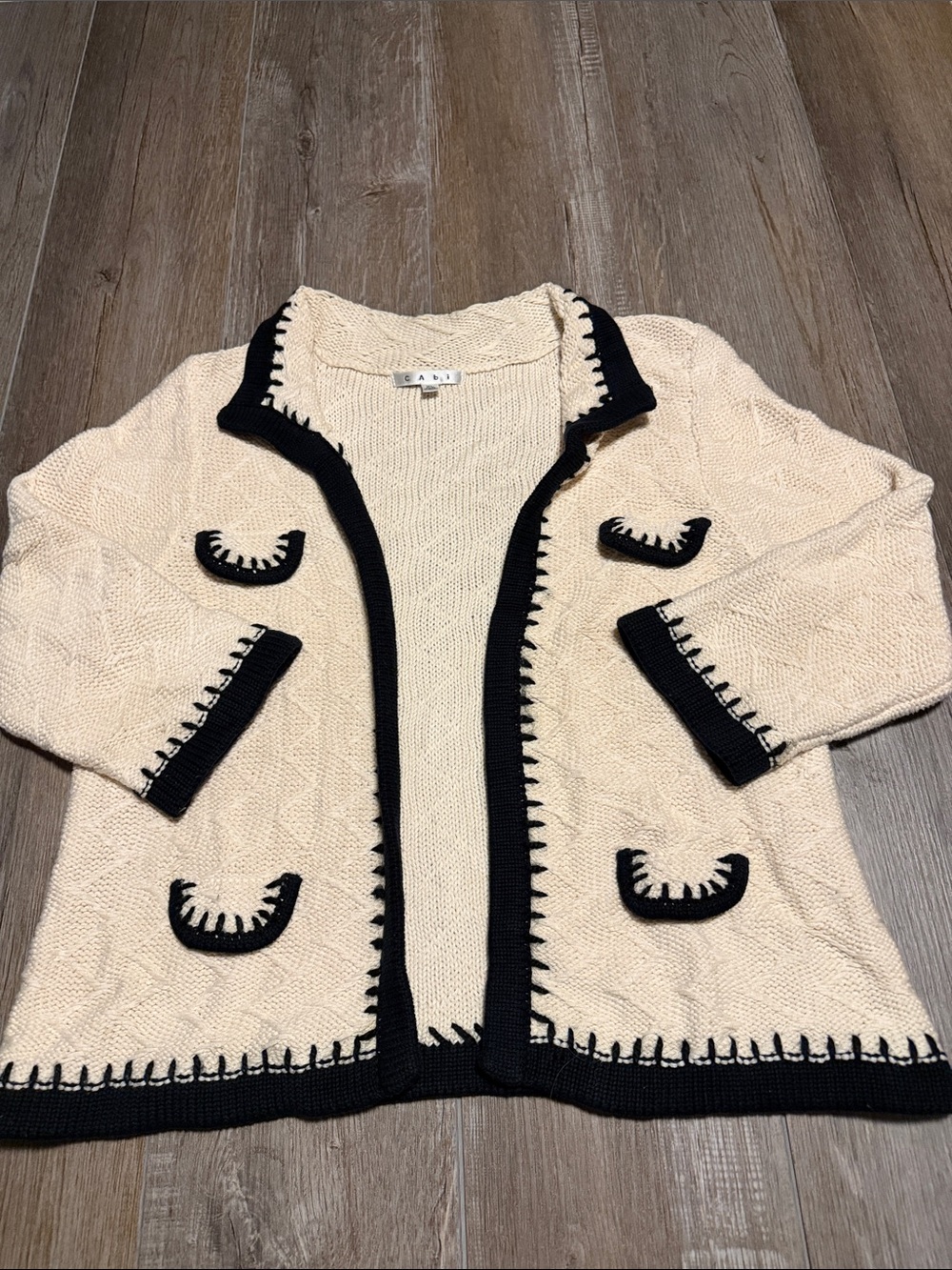 Cabi Socialite Cardigan features an ivory cable knit fabric